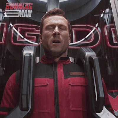 Man In Red And Black Suit Riding Roller Coaster With Running Man Sign GIF