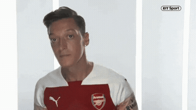 Man In Red And White Arsenal Jersey Looking At Camera GIF