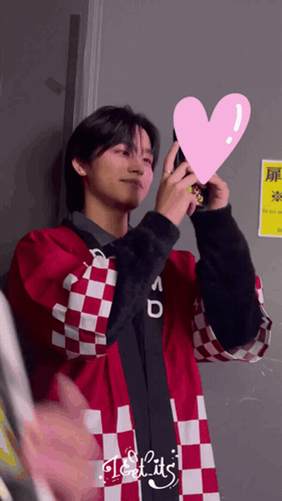 Man In Red And White Checkered Jacket Holding Pink Heart GIF