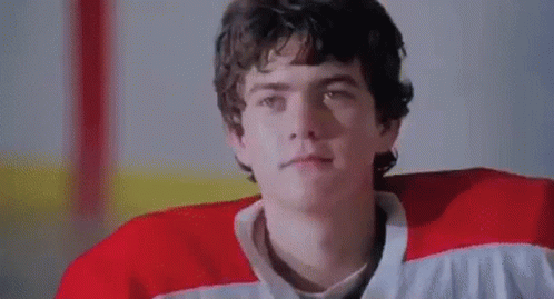 Man In Red And White Hockey Jersey In Locker Room GIF