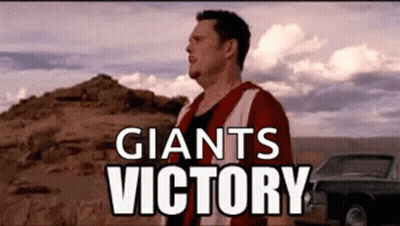 Man In Red And White Jersey Standing In Front Of Mountain And Car GIF
