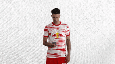 Man In Red And White Shirt With Red Bull Looking At Phone GIF