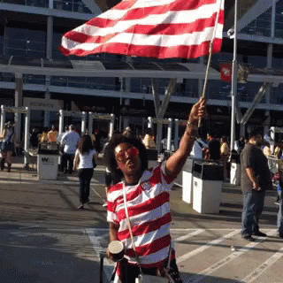 Man In Red And White Striped Shirt Holding Flag GIF