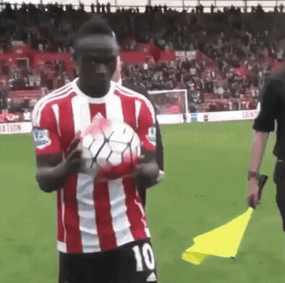 Man In Red And White Striped Shirt Holding Soccer Ball GIF
