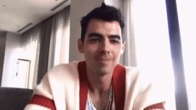 Man In Red And White Striped Sweater Sitting By Window GIF