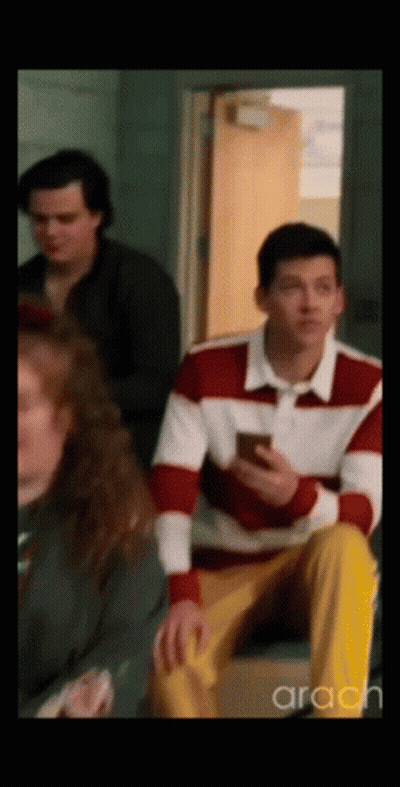 Man In Red And White Sweater Looking At Phone GIF