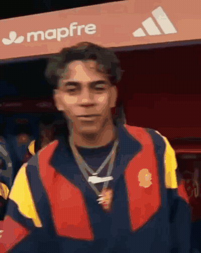 Man In Red And Yellow Jacket In Front Of Mapfre Sign GIF