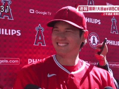 Man In Red Angels Jersey Smiling In Front Of Google TV Sign GIF