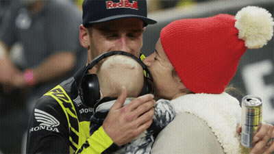 Man In Red Bull Hat Kissing Baby GIF