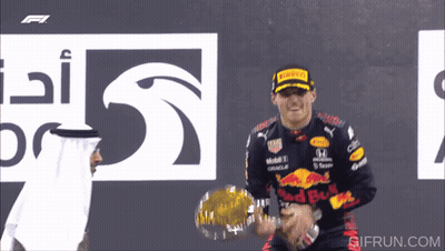 Man in Red Bull Jacket Holding Trophy