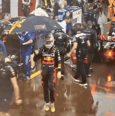 Man In Red Bull Outfit Holding Umbrella Over Head GIF