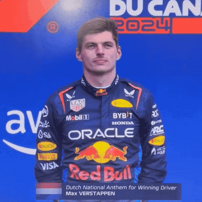 Man In Red Bull Racing Suit In Front Of Blue Wall GIF