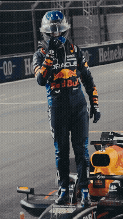 Man In Red Bull Racing Suit Next To Race Car GIF