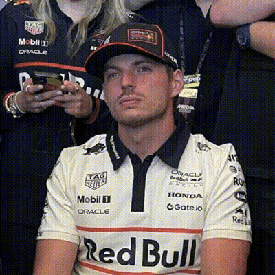 Man In Red Bull Shirt And Hat Sitting In Front Of Crowd GIF