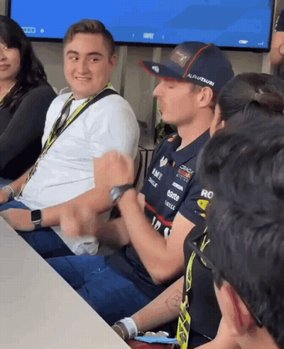 Man In Red Bull Shirt Sitting At Table GIF