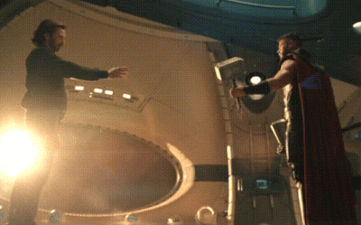 Man In Red Cape Next To Man In Black Shirt GIF
