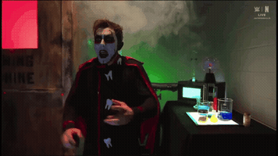 Man In Red Cape Standing By Warning Mine Sign GIF