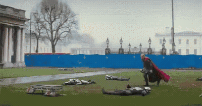 Man In Red Cape Standing In Field GIF
