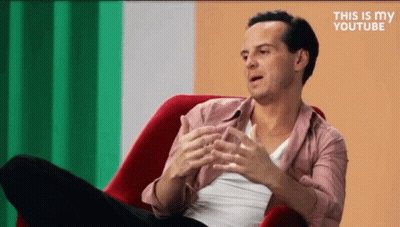 Man In Red Chair Crossed Legs Talking GIF