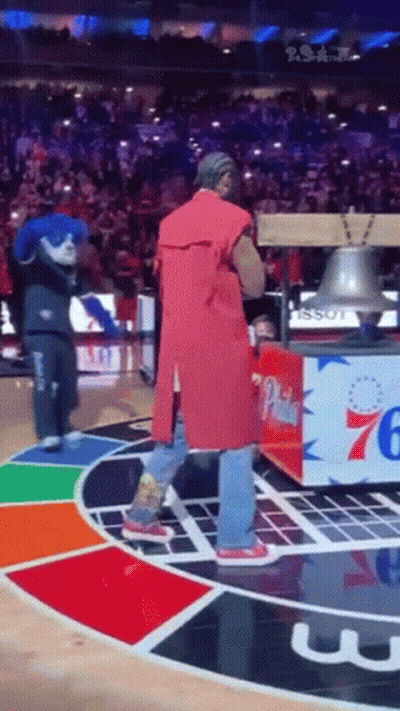 Man In Red Coat Holding Bell On Basketball Court GIF