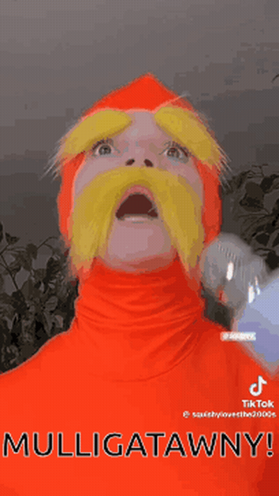 Man In Red Costume Holding Microphone Saying Mulligatawny GIF