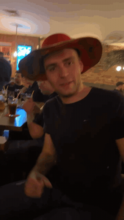 Man In Red Cowboy Hat Sitting At Table GIF