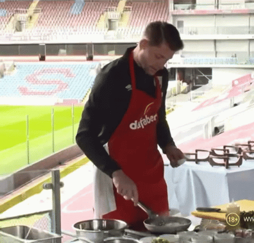Man In Red Dafabet Apron Cooking GIF