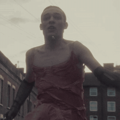 Man In Red Dress And Black Gloves Walking GIF