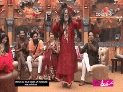 Man In Red Dress Dancing In Front Of People On Couches GIF