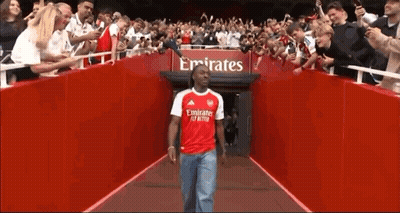 Man In Red Emirates Shirt Walking Through Tunnel Of Fans GIF