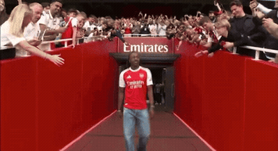 Man In Red Emirates Shirt Walking Through Tunnel GIF