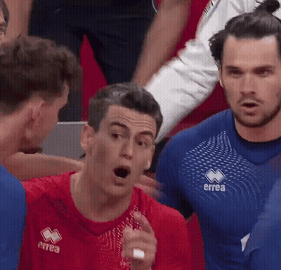 Man In Red Errea Shirt Talking To Another Man GIF