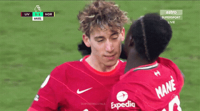 Man In Red Expedia Shirt Kissing Another Man GIF
