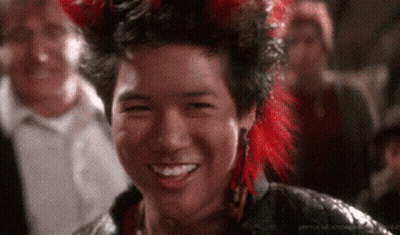 Man In Red Feathered Headdress Smiling In Crowd GIF