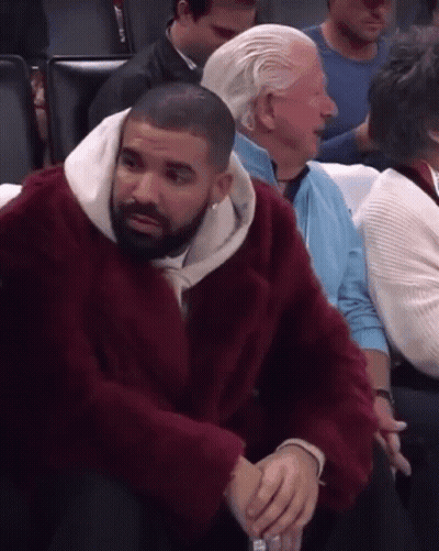 Man In Red Fur Coat Sitting In Stadium GIF