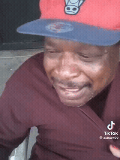 Man In Red Hat And Black Shirt Smiling GIF