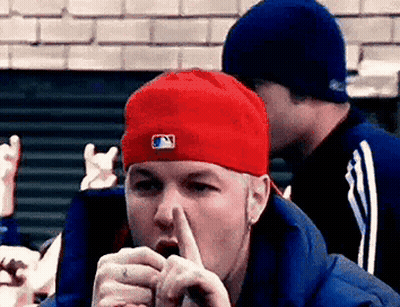 Man In Red Hat And Blue Jacket Covering Mouth GIF