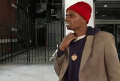 Man In Red Hat And Brown Jacket By Fence GIF