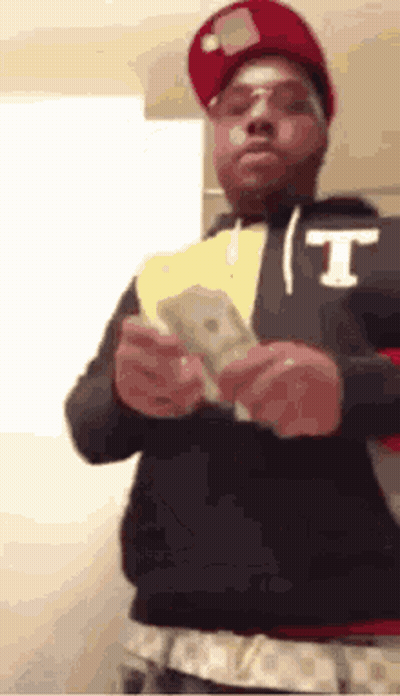 Man In Red Hat And Glasses Holding Money GIF
