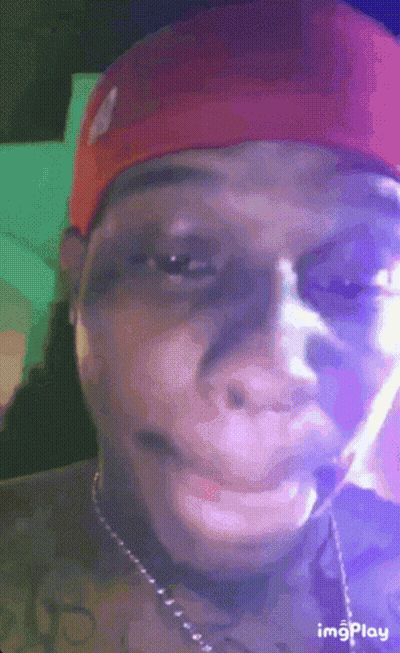 Man In Red Hat And Necklace Smoking Cigarette GIF