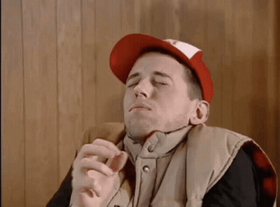 Man In Red Hat And Vest Smoking Cigarette GIF