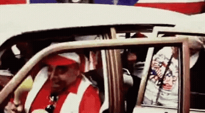 Man In Red Hat And White Vest Driving White Car GIF