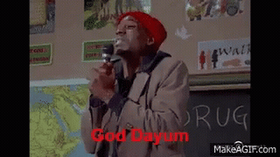 Man In Red Hat Holding Microphone In Front Of Chalkboard Saying Drug GIF