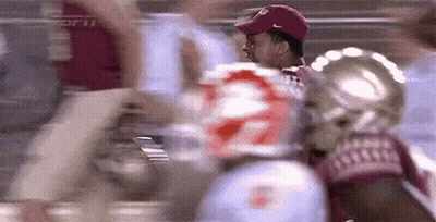 Man in Red Hat in Front of Football Player Number 22