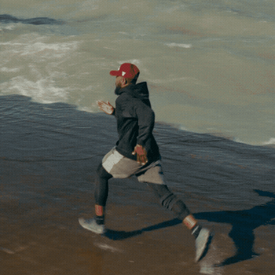 Man In Red Hat Running On Beach GIF