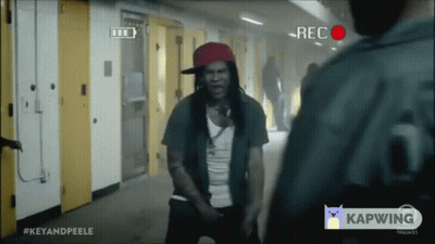 Man In Red Hat Standing In Front Of Camera Saying Rec GIF