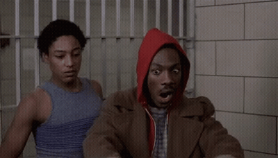 Man In Red Hoodie Sitting In Jail Cell With Another Man GIF
