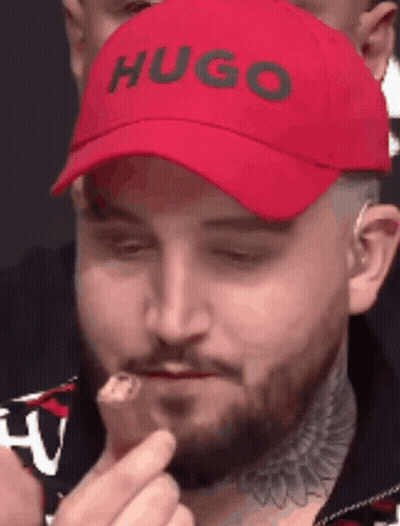 Man In Red Hugo Hat Eating Food GIF