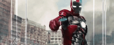Man In Red Iron Man Suit Standing In Front Of Building GIF