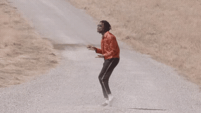 Man In Red Jacket And Black Pants On Gravel Road GIF